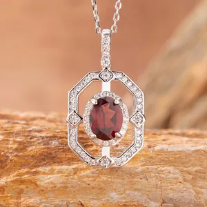 Macro dettaglio di un ciondolo ottagonale in argento S925 con granato rosso ovale.