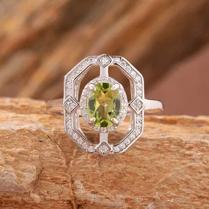 Primo piano dettagliato di un anello in argento con peridoto e alone di diamanti ottagonale