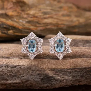 Elegant s925 silver stud earrings with light blue oval gemstones in a floral halo setting