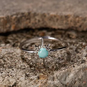 Close-up of S925 sterling silver sunburst ring with turquoise stone on stone background