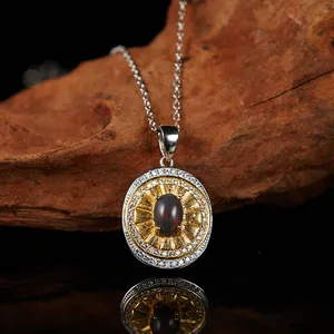 Detail view of a vintage oval garnet pendant with sunburst gold plating and clear stones.