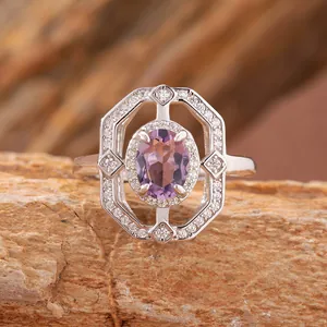 Vista dettagliata di un anello in argento con ametista viola e castone a aureola.