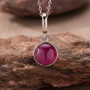 Detail view of a 925 sterling silver necklace featuring a round magenta agate pendant