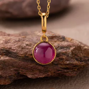 Detailed view of a round red agate pendant set in a 925 sterling silver gold-plated frame