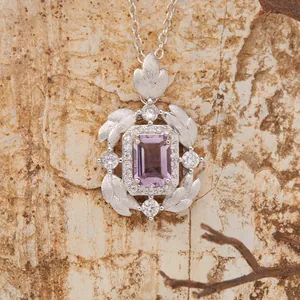 Macro view of sterling silver amethyst pendant with detailed brushed feather leaf elements