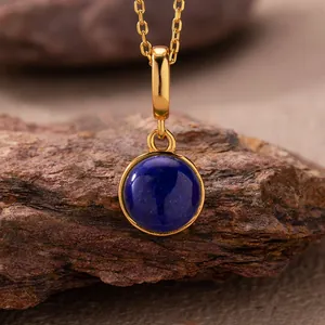 Detailed macro view of a circular blue lapis lazuli gemstone pendant on a gold chain