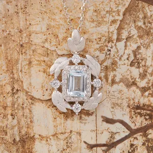 Detailed macro of S925 silver pendant with emerald cut blue gemstone and brushed feathers