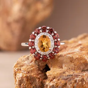 Makroansicht eines Sterlingsilberrings mit ovalem Citrin und rotem Granat-Heiligenschein