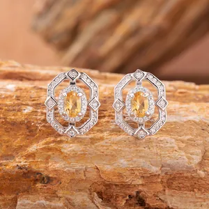 Dettaglio di orecchini in argento sterling 925 con gemma gialla ovale incastonata
