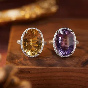 Close-up macro view of natural citrine and amethyst S925 silver halo rings on wood.