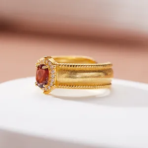 Primo piano di un anello vintage in oro spazzolato con granato e pietre brillanti