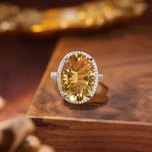 Detailed close-up of millennium cut oval citrine ring in S925 silver halo setting