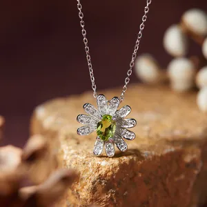 Detailed close-up of a silver daisy necklace pendant featuring a green oval gemstone center