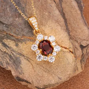 Detailed macro view of a sterling silver sunburst pendant with natural red garnet