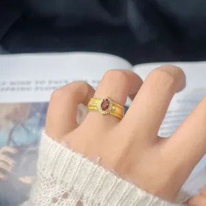 Primo piano di un anello vintage in argento S925 con granato e oro spazzolato