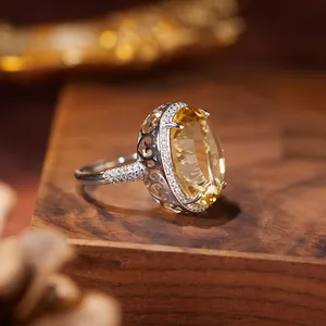 Close-up detail of a large oval citrine silver ring with hollow engraved side patterns
