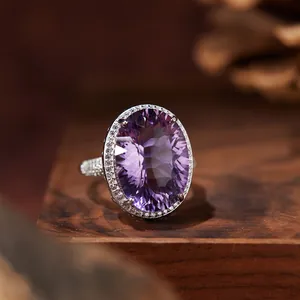 Close-up of a large oval purple amethyst ring on a wooden background