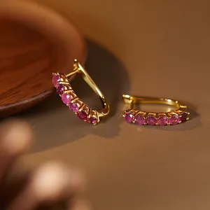 Macro detail of S925 sterling silver hoop earrings micro-set with natural red rubies