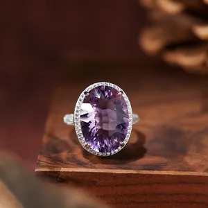 Macro detail of oval millennium cut purple amethyst set in a silver halo engagement ring