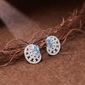 Détail de boucles d'oreilles ajourées vintage en argent S925 avec topaze bleue