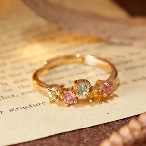 Squisito primo piano di un anello in argento S925 dorato con cinque tormaline colorate