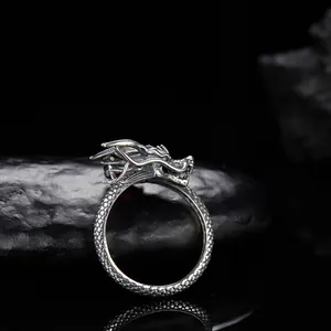 Primo piano dettagliato di un anello a forma di drago in argento 925 con granato.