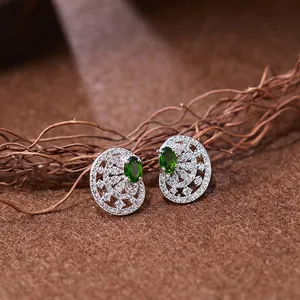 Gros plan de boucles d'oreilles vintage en argent avec diopside vert et cristaux pavés