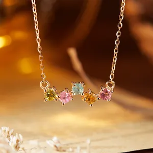 Dettaglio macro di una collana oro rosa con cinque tormaline tonde colorate naturali