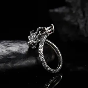 Vista laterale dettagliata di un anello a forma di drago in argento S925 con granato.