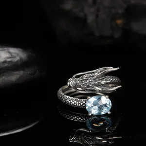 Dettaglio di un anello a forma di drago in argento vintage con topazio blu sfaccettato.