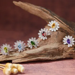 Detailansicht von sechs silbernen Gänseblümchen-Ohrringen mit bunten ovalen Edelsteinen.