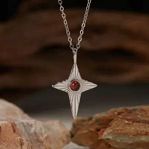 Close-up of S925 sterling silver star pendant necklace with natural red garnet stone.