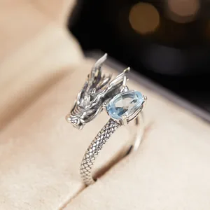 Dettaglio macro di un anello a forma di drago in argento sterling S925 con topazio azzurro