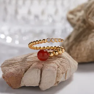 Vista detallada macro de un anillo de plata dorada con ágata roja y gemas claras