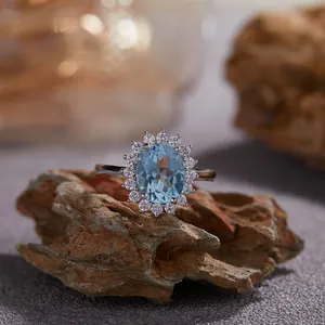 Détail d'une bague topaze bleue ovale avec un halo étincelant sur pierre