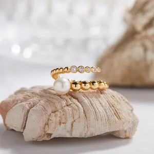 Detalle de primer plano de un elegante anillo abierto dorado con una perla de agua dulce blanca