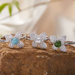 Close-up of S925 sterling silver rings featuring natural larimar pearl and jasper clover designs