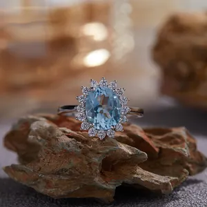 Vue macro d'une bague topaze bleue avec halo sur fond de pierre naturelle