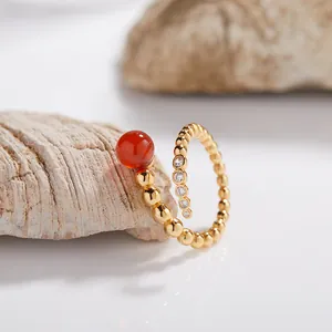 Primer plano de un elegante anillo de cuentas chapado en oro con ágata roja y circonio
