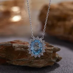 Détail macro d'un collier avec pendentif en topaze bleue naturelle ovale en argent massif