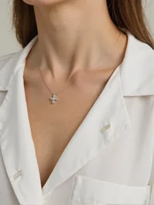 Detail view of a sterling silver necklace with natural pearl and blue gems on a model.
