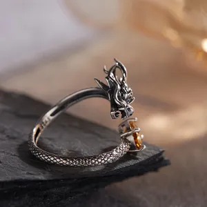Primo piano dettagliato di un anello a forma di drago in argento S925 con topazio giallo
