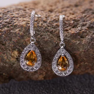 Dettaglio ravvicinato di orecchini a goccia in citrina e argento con pietre