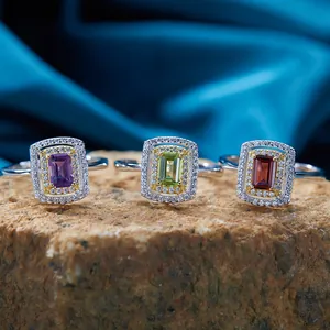 Dettaglio macro di tre anelli in argento con ametista, peridoto e granato.