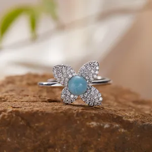 Macro view of S925 silver flower ring featuring a blue larimar stone and pavé crystals