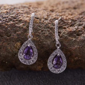Primo piano di orecchini a goccia eleganti con ametista viola e contorno in argento