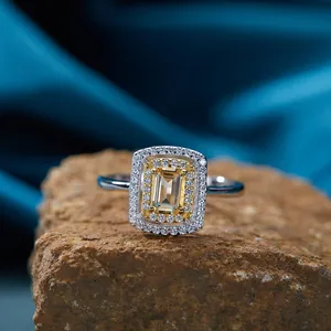 Primo piano di anello in argento S925 con citrina gialla rettangolare e doppia montura halo.