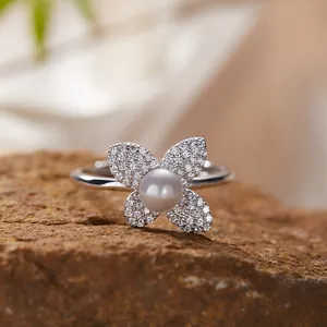 Macro detail view of a sterling silver clover ring with center pearl and paved stones