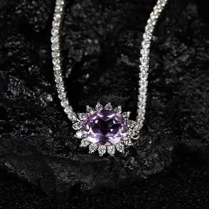 Magnifique pendentif en améthyste avec halo de pierres sur fond de roche noire texturée.