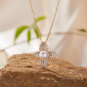 Close-up of elegant four-petal flower necklace with white pearl and sparkling crystals